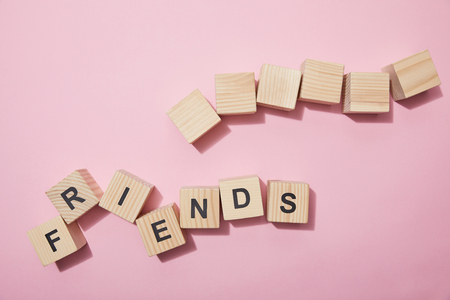 Top view of wooden cubes with letters on pink surfaceの写真素材