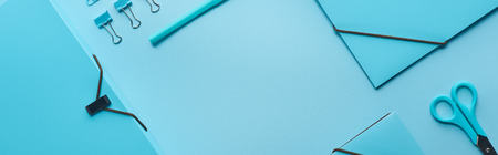 Panoramic shot of paper folders and organized stationery isolated on blue with copy spaceの写真素材