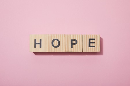 Top view of wooden cubes with letters on pink surfaceの写真素材