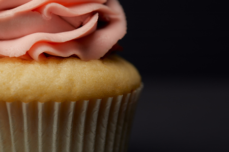 Close up view of cupcake with cream on black backgroundの写真素材