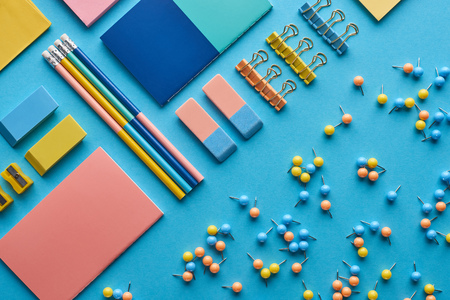 Top view of notebooks and various colorful stationery isolated on blue backgroundの写真素材