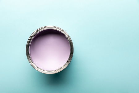 Top view of tin with purple paint on blue surface