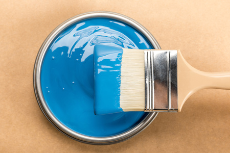 Top view of tin with blue paint and brush on brown backgroundの写真素材