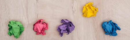 Panoramic shot of crumpled paper balls on wooden table, solution concept