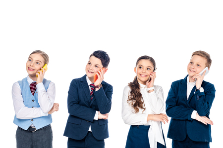 happy schoolchildren pretending to be businesspeople talking on smartphones Isolated On Whiteの写真素材