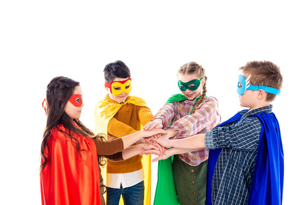 kids in superhero costumes and masks Stacking Hands Isolated On Whiteの写真素材