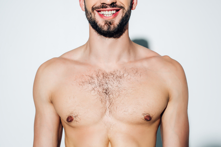 Cropped view of cheerful and shirtless man smiling on white backgroundの写真素材