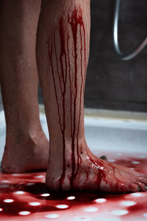 partial view of barefoot bleeding woman in bathroomの写真素材