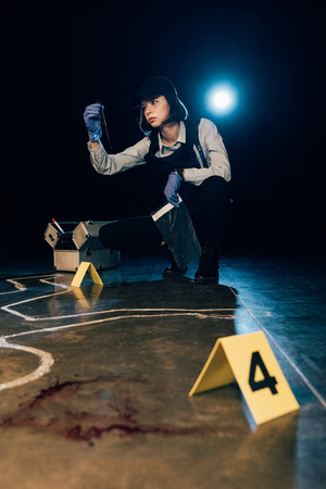 investigator holding knife and ziploc bag at crime sceneの写真素材