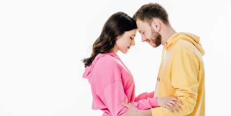 panoramic shot of young man and woman standing face to face isolated on whiteの写真素材