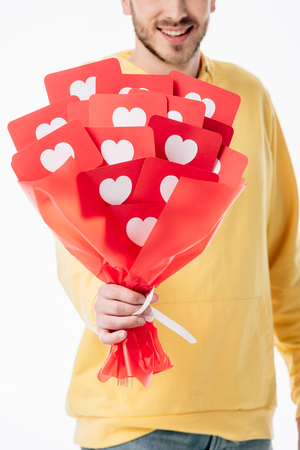 cropped view of smiling man holding bouquet of red paper cards with hearts symbols isolated on whiteの写真素材