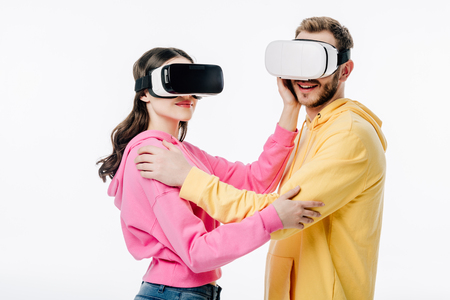 young man and woman embracing while using virtual reality headsets isolated on whiteの写真素材