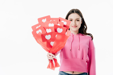 pretty smiling girl holding bouquet of red paper cut cards with hear symbols isolated on whiteの写真素材