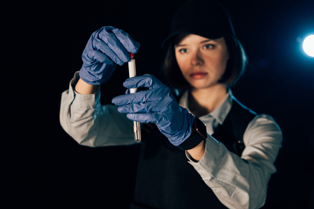 selective focus of investigator in rubber gloves holding swab and test tube at crime sceneの写真素材