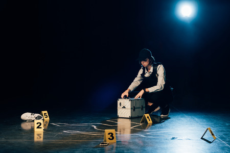 investigator with investigation kit near chalk outline at crime sceneの写真素材