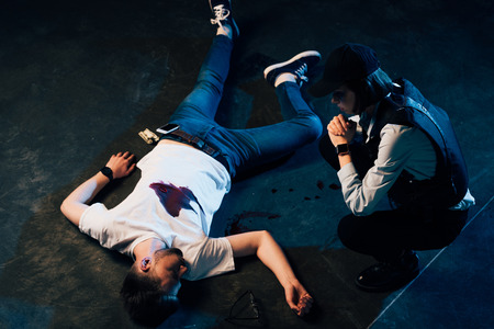 overhead view of investigator sitting near cadaver at crime sceneの写真素材