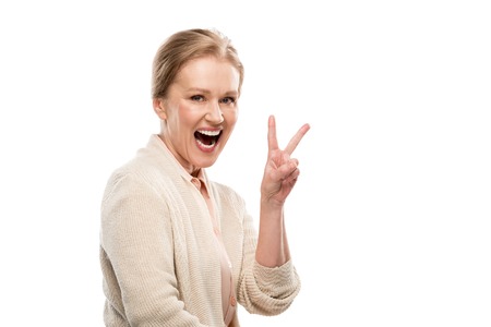 Excited middle aged woman showing Peace Sign isolated on white background