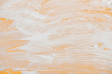 Glass covered with white foam on orange backgroundの写真素材