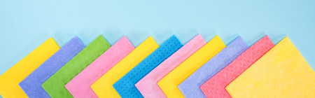 Panoramic shot of bright multicolored rags on blue backgroundの写真素材