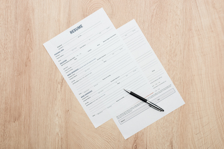 Top view of print resume templates and pen on wooden tableの写真素材