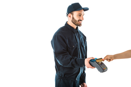 Cropped view of female hand with credit card near cheerful delivery man holding payment terminal...