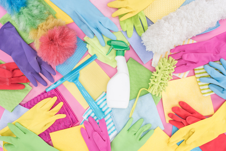 Top view of messy scattered multicolored cleaning supplies on pink backgroundの写真素材
