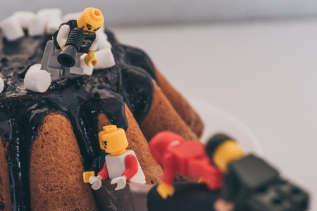 KYIV, UKRAINE - MARCH 15, 2019: lego character with mouthpiece standing on cake and shouting at figurines cutting cakeのeditorial素材