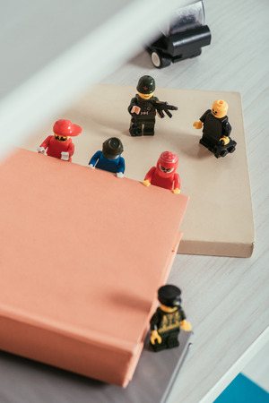 KYIV, UKRAINE - MARCH 15, 2019: high angle view of plastic lego minifigures carrying book near guard figures with gun and mouthpieceのeditorial素材