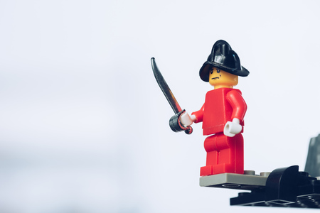 KYIV, UKRAINE - MARCH 15, 2019: red lego pirate figure in hat holding sword on white with copy spaceのeditorial素材
