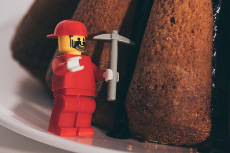 KYIV, UKRAINE - MARCH 15, 2019: close up view of plastic lego figurine with toy icebreaker near cake