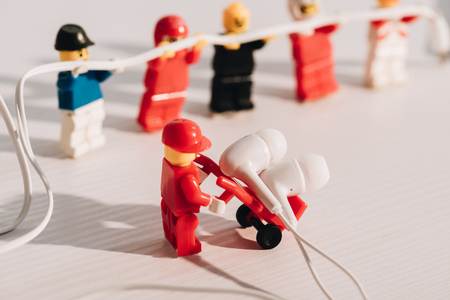 KYIV, UKRAINE - MARCH 15, 2019: Selective Focus of lego figurine carrying earphones in trolley on...
