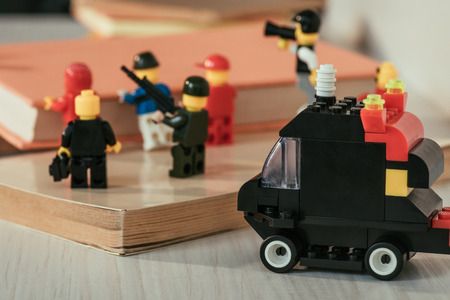 KYIV, UKRAINE - MARCH 15, 2019: close up view of plastic lego minifigures carrying book near guard...