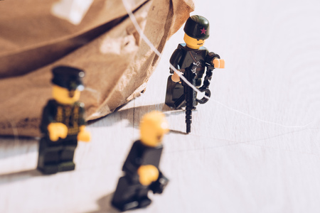 KYIV, UKRAINE - MARCH 15, 2019: lego policemen minifigures with gun and handcuffs on white tableのeditorial素材