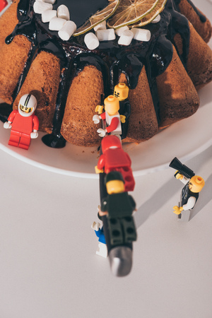 KYIV, UKRAINE - MARCH 15, 2019: plastic lego minifigures cutting cake with knife on whiteのeditorial素材
