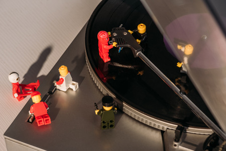 KYIV, UKRAINE - MARCH 15, 2019: colorful plastic lego figurines fixing vinyl record playerのeditorial素材