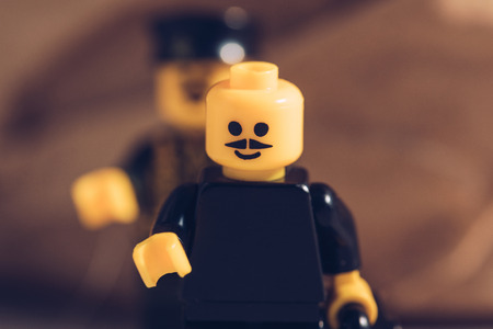 KYIV, UKRAINE - MARCH 15, 2019: selective focus of black lego figurine with moustache and smiley...