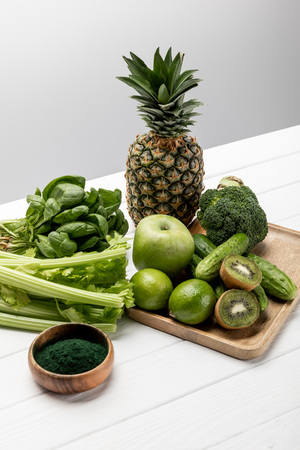 tasty fresh fruits near organic and raw vegetables on greyの写真素材