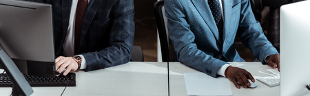 panoramic shot of multicultural businessmen working in office