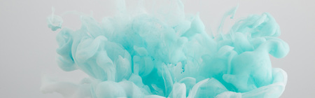 Close up view of light blue paint swirls isolated on greyの写真素材