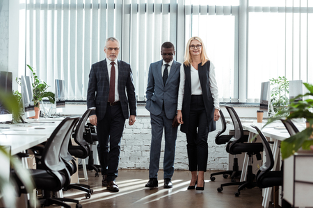 selective focus of african american businessman walking near partners in officeの写真素材