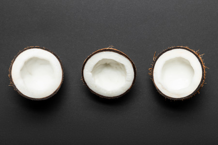 top view of coconut halves on black backgroundの写真素材