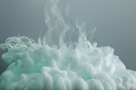 Close up view of light green paint swirls isolated on greyの写真素材