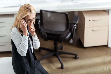 overhead view of thoughtful businesswoman talking on smartphoneの写真素材