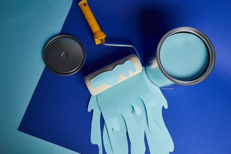top view of metal shiny can near roller with dripping paper cut paint on bright blue backgroundの写真素材