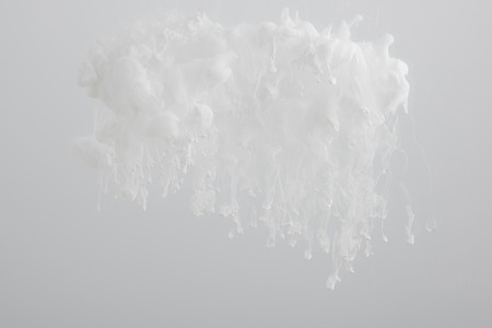 Close up view of white paint swirls isolated on greyの写真素材