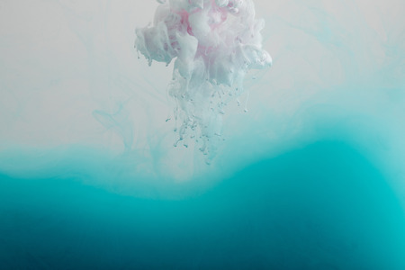 Close up view of white and turquoise watercolor paint swirls isolated on grey