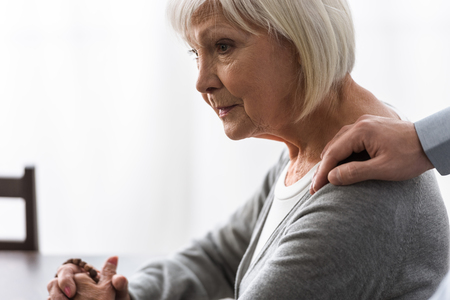 partial view of man supporting senior mother with grey hairの写真素材
