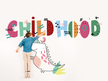 Top view of cute kid gesturing near childhood lettering on white backgroundの写真素材