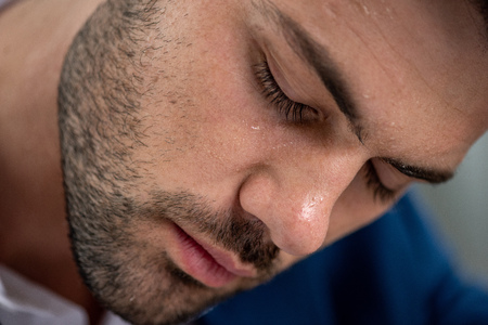 Handsome exhausted man with sweaty face suffering from heat on grey backgroundの写真素材