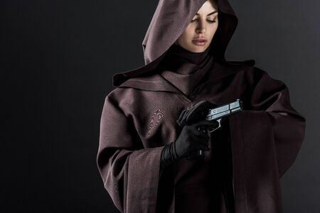 Woman in death costume holding gun isolated on black backgroundの写真素材